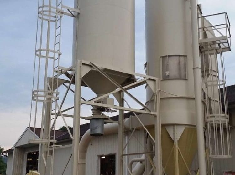 Industrial paint-coated storage silos with supporting platforms and access ladders.