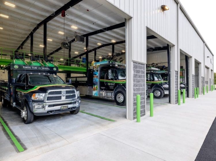 A large commercial vehicle wash bay with multiple cleaning stations and equipment. The facility is equipped with state-of-the-art washing systems and has a clean, industrial finish