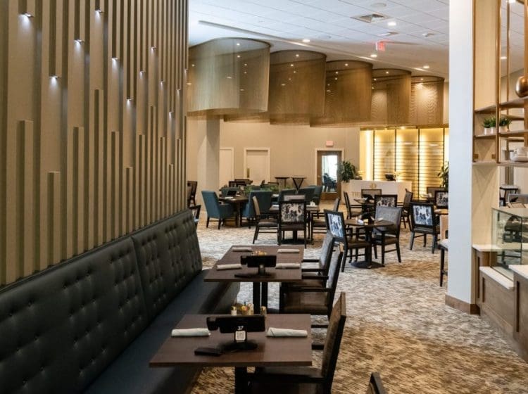 Spacious dining area with modern decor, including a large upholstered seating area along the wall. The room features unique lighting fixtures and a contemporary design