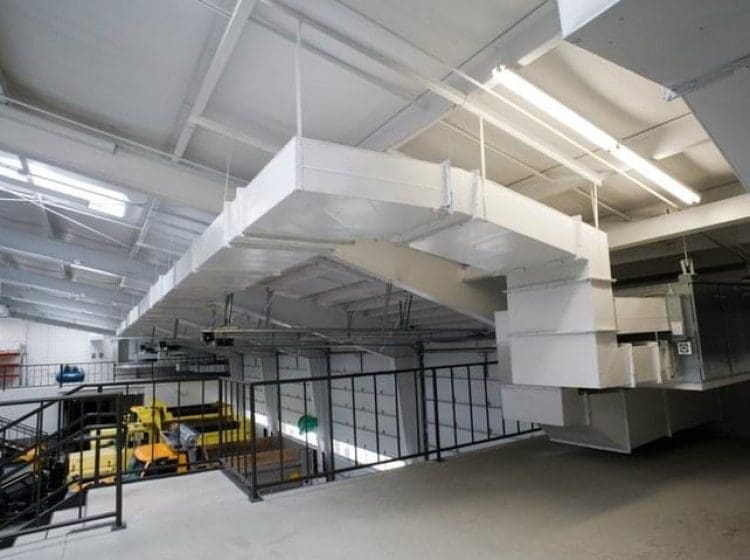 Industrial ventilation system and ductwork installed above a mezzanine level in a large commercial building