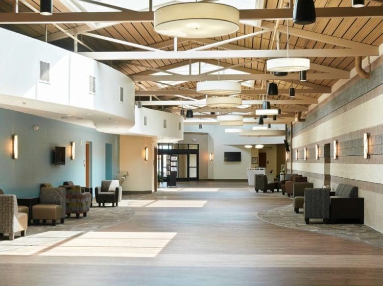 A bright church hallway with vaulted ceilings, modern lighting, and seating areas along the walls.