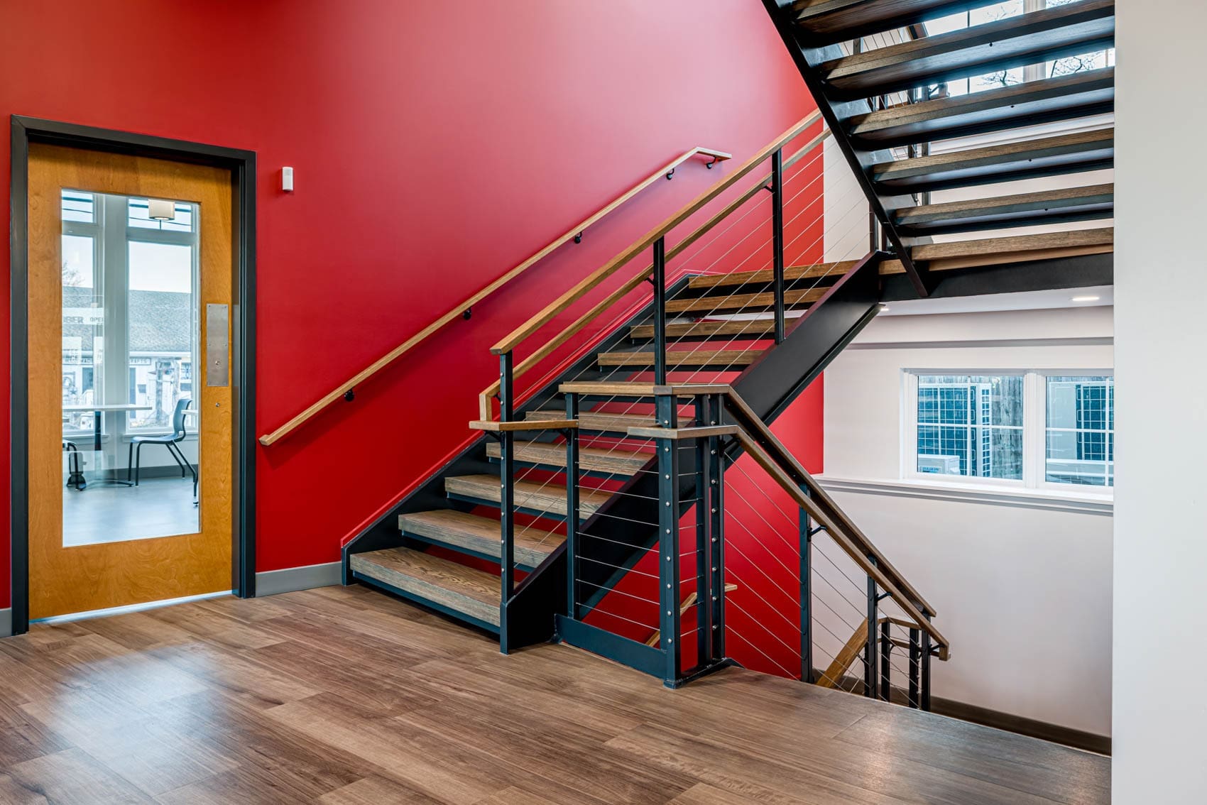 business office painting services red wall against wooden staircase